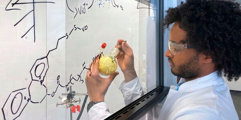 Dawit T. Filmon, Mitarbeiter von Prof. Nicolas Plumere, hält einen Ausgangsstoff für die Seitenketten des schützenden Polymers in seinen Händen.