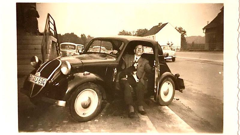 Unterwegs mit Hund und Hausschuhen: Uropa Willi Senst in seinem Fiat 500 („Topolino“). Die Aufnahme entstand in Rohrbach/Saar im Jahr 1963.