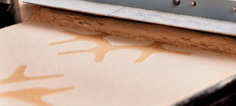 Während des Druckprozesses werden Schichten aus speziell behandeltem Sägemehl durch ein biologisch abbaubares Bindemittel selektiv verbunden.