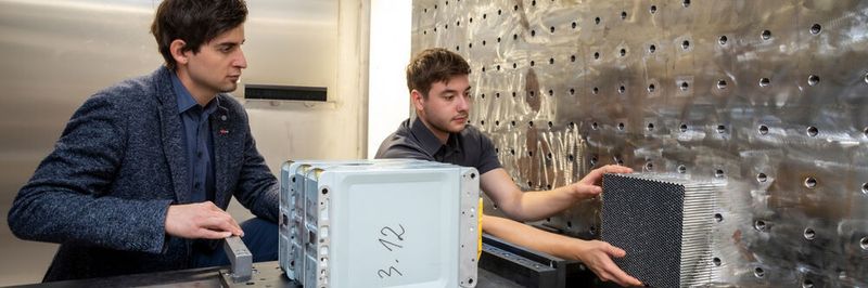 Untersuchungen der TU Graz zeigen: Batterien von E-Autos werden unterm Strich sicherer mit dem Alter. Im Bild: Projektleiter Christian Ellersdorfer mit Kollegen Christian Trummer bei der Batterien-Crashanlage des Battery Safety Center Graz.
