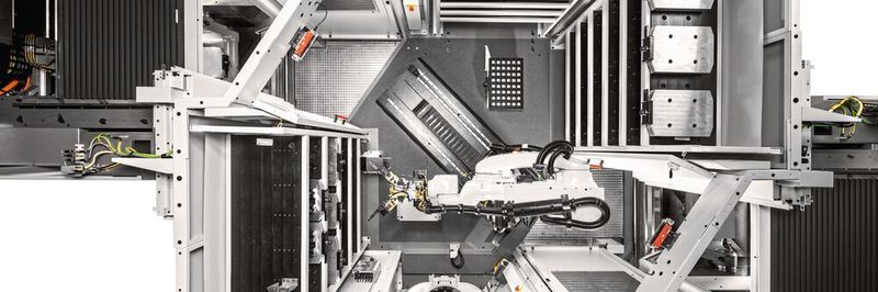 Draufsicht in das Robotersystem RS 1 adaptiert an zwei Hermle-Bearbeitungszentren C 22 U links und rechts – bis zu drei Speichermodule sorgen für eine lange autonome Laufzeit und beherbergen Paletten, Universalmatrizen und Greifer.