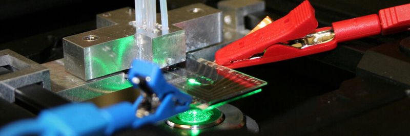 Prototyp einer membranlosen mikrofluidischen Brennstoffzelle bei der elektrochemischen und strömungsmechanischen Charakterisierung auf dem Mikroskop.