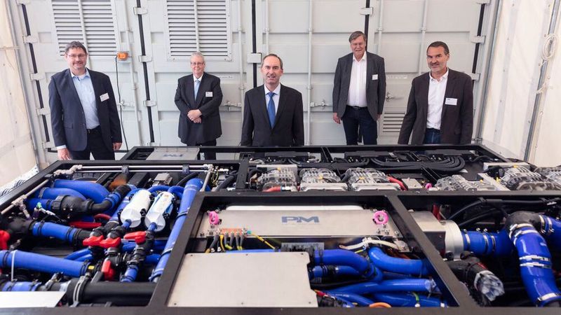 Hubert Aiwanger (Mitte) vor dem neuen Multistack-System mit den Proton-Motor-Geschäftsführern Sebastian Goldner, Roman Kotlarzewski, Klaus Bury und Manfred Limbrunner (von links).