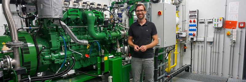 Prof. Dr. Raphael Lechner zeigt eines der Blockheizkraftwerke am Kompetenzzentrum für Kraft-Wärme-Kopplung.