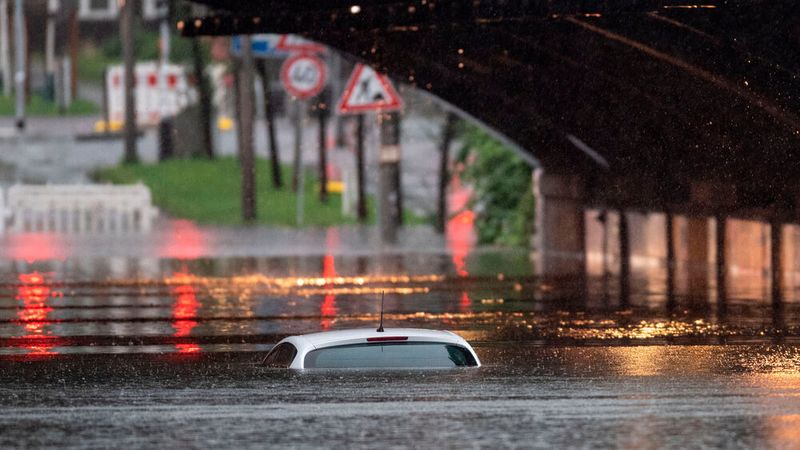 Nur das Dach eines Autos schaut noch aus dem Wasser, das eine Bahnunterführung in Nordrhein-Westfalen geflutet hat.