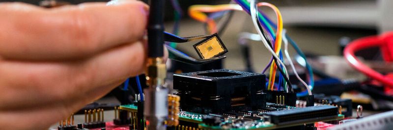 Platzierung des Chips auf der Testplatine: Tim Fritzmann, wissenschaftlicher Mitarbeiter am Lehrstuhl Sicherheit in der Informationstechnik, platziert den Chip mithilfe einer Pinzetteauf der Testplatine. Über den Prozessorsockel kann der Chip schnell aus- und eingebaut werden.