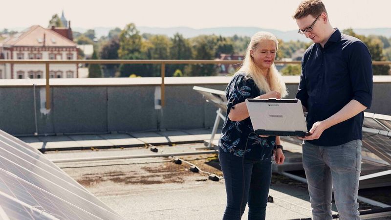 Grit Behrens (links) und Felix Meyer messen Kennlinien an der Photovoltaikanlage auf dem Dach des Gebäudes D auf dem Campus Minden der FH Bielefeld.