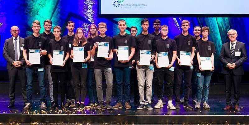 Die Gewinner des diesjährigen, vom BMBF und VDE ausgetragenen Wettbewerbs „Invent a Chip“, flankiert von Prof. Wolf-Dieter Lukas, Staatssekretär im BMBF, und Ansgar Hinz, CEO des VDE. Die zehn besten Teilnehmerinnen und Teilnehmer stellten sich zusätzlich einer besonderen Herausforderung, der „Invent a Chip-Challenge“, bei der eine Solarzelle motorisch so bewegt werden sollte, dass sie dem Sonnenstand folgt.