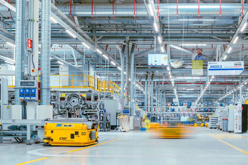 Die Produktion von Doppelkupplungsgetrieben bei Magna in Italien. Links auf dem gelben FTS ist ein Getriebe zu sehen.
