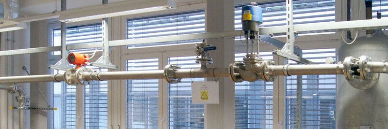 Hydraulikprüfstand zur Effizienzmessung nach ISO 9906. Das spezielle Beruhigungsgefäß rechts im Bild ist Voraussetzung für eine gleichmäßige Strömung und ermöglicht zudem die Erwärmung der Flüssigkeit, in der Regel Wasser.