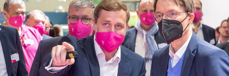 Gesundheitsminister Karl Lauterbach (r.) informierte sich auf der DMEA am Stand der Deutschen Telekom über IT-Sicherheitslösungen für kritische Infrastrukturen. Gottfried Ludewig (l.), erklärte das Zusammenspiel von Netzüberwachung, dem Monitoren von medizinischen Endgeräten und Gegenmaßnahmen