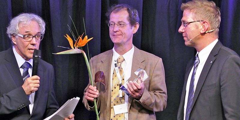 Prof. Hermann de Meer (Mitte) bei der Preisverleihung in Sinsheim mit Moderator Gerd Marohn (links) und Bernd Fleischer, Leiter Business Development, Zentralvertrieb des Sponsors Hochtief Solutions AG (Foto: Uni Passau)