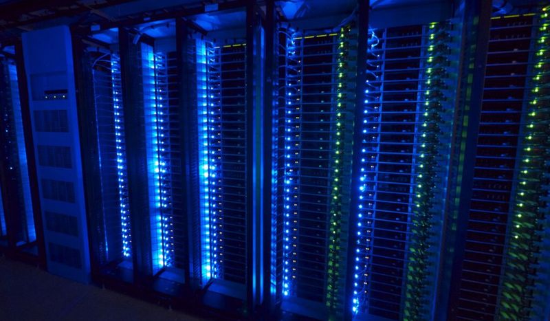 Open-Source-Design oder doch Hardware von Dell, HP, IBM und anderen Markenherstellern anstelle von UCS? Das Foto zeigt Open Compute Servers, die in einer Dreierformation aufgestellt sind: drei benachbarte 42U Säulen. Jede ist mit 2 TOR-Switches ausgestettet und 30 Server. One battery cabinet sits in between a pair of triplet racks in the data center aisle, providing DC power in the event of loss of AC power.