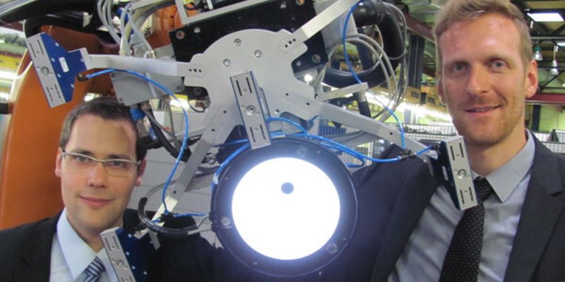 Durch die Integration des Kamerasystems greift der Roboter das Textil immer optimal. Philipp Kosse, Werkzeugmaschinenlabor, WZL (links), und Christoph Greb, Institut für Textiltechnik (rechts) erklären im WZL-Robolab das Konzept.