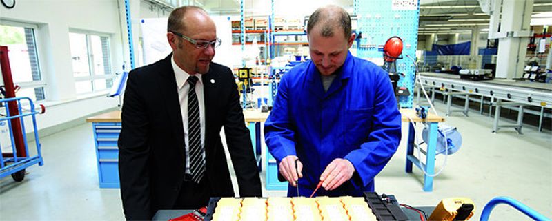 Stefan Suckow (l.), Managing Director für das Batteriegeschäft bei Johnson Controls, bei einem Rundgang durch die Lithium-Ionen-Produktion.