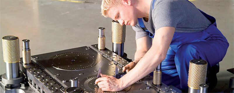 Ein Werkzeugmacher bei der Endkontrolle vor dem Zusammensetzen von Werkzeugober und-unterteil. Die Elektromobilität bringt neue Anforderungen auch für den Werkzeugbau.