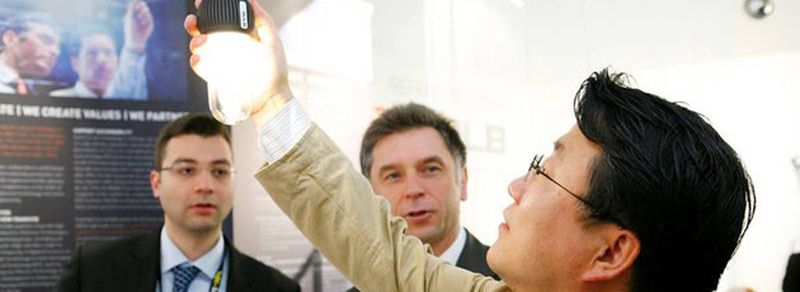 Prof. Dr. Holger Heuermann (rechts hinten) von der FH Aachen präsentiert die quecksilberfreie Energiesparlampe: Grundlage sind Leistungsverstärker im Mikrowellenbereich