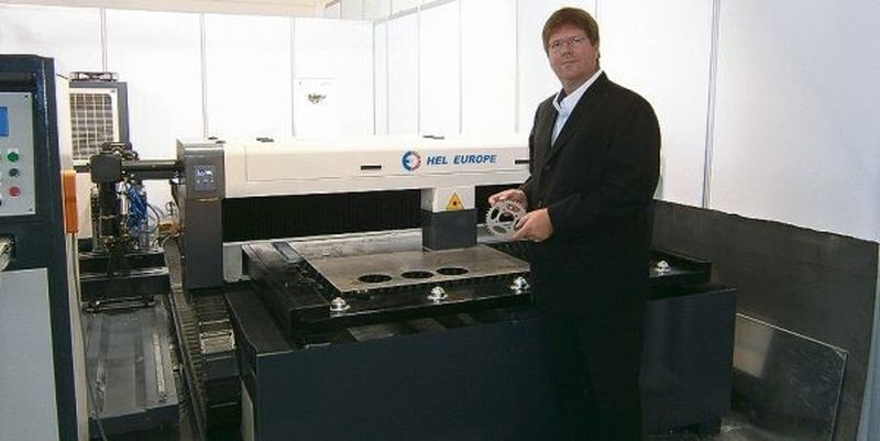 Krisha Bogacki, Leiter Automatisierung und Vertrieb, vor der CNC-Laserschneidmaschine Eco von HEL, die laut Angaben ohne Schutzumhausung betrieben werden darf.