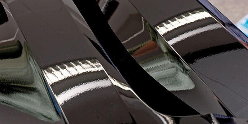 Mit bloßem Auge zu sehen: Auf dem rechten Kotflügel aus Primetex spiegelt sich der Lichtstreifen klar wider, beim Standardkotflügel links ist das Spiegelbild unruhig.