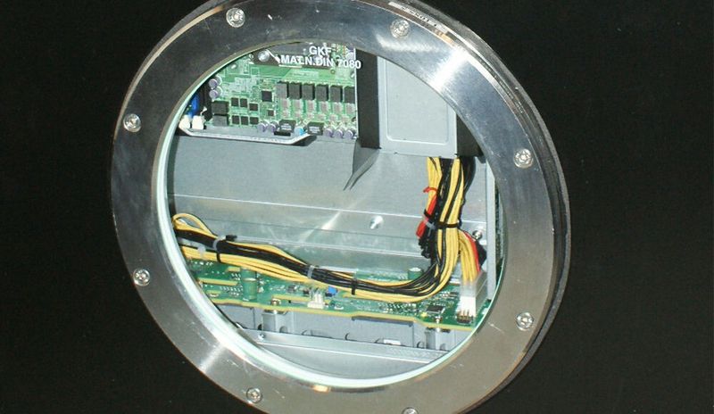 Durch das Guckloch lässt sich ein Supermicro-Server in der 3M-Flüssigkeit Novec erkennen.