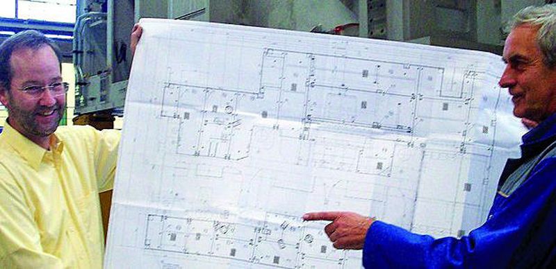 Mark Behring (l.), Leiter Innenmontage und Klaus Karolewski, Montageplanung, beide Schuler Pressen GmbH in Erfurt, zeigen den Montageplan, auf dem alle wichtigen Schritte für die Transportvorbereitung zu sehen sind.