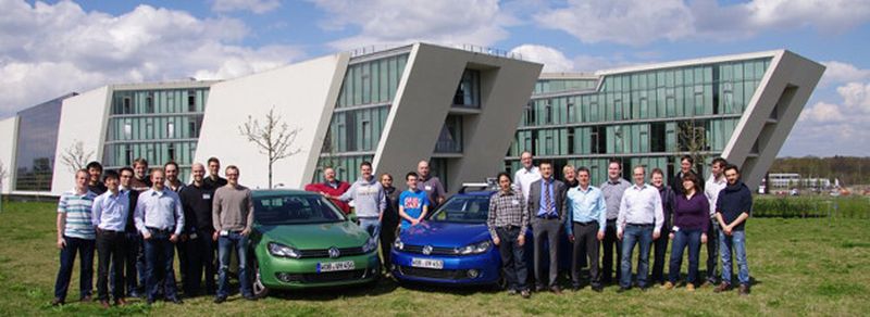 Wollen Elektroautos autonom parken und laden: die Mitglieder des V-Charge-Teams mit ihren beiden Versuchsfahrzeugen