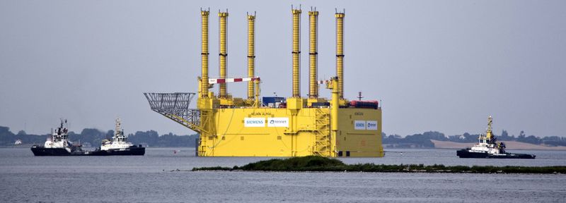 Drei Schlepper sind nötig um die 11.000 Tonnen schwere Konverterplattform vor die Küste Helgolands zu ziehen. Da der Stahlkoloss zu groß für den Nord-Ostsee-Kanal ist, wurde er um die Nordspitze Dänemarks herumgeschleppt. Nach sieben Tagen auf See und 990 zurückgelegten Kilometern hat HelWin1 nun ihren Installationsort erreicht.