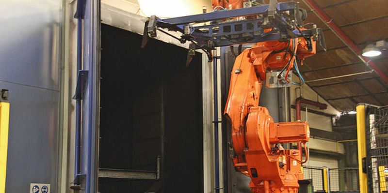 Bild 1: In der Strahlanlage befreit RHI seine stählernen Umlaufpaletten von Teerrückständen, die Handhabung übernimmt ein Roboter.