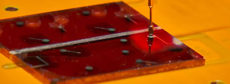 Ein Glas-Substrat mit mehreren Solarzellen aus dem flüssig-prozessierten Silizium im Sonnensimulator, in dem der Wirkungsgrad gemessen wird.
