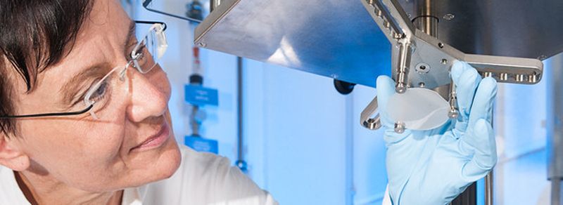 Eine Mitarbeiterin des Fraunhofer-Technologiezentrums Halbleitermaterialien THM in Freiberg inspiziert ein Galliumnitrid-Substrat.