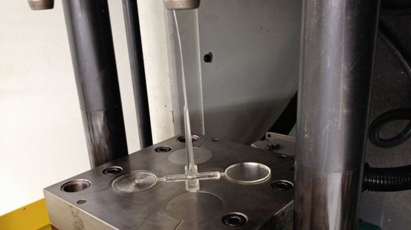 Bild 3: Bewegliche Hälfte des Versuchswerkzeugs mit Angusssystem und erstarrtem Teil.