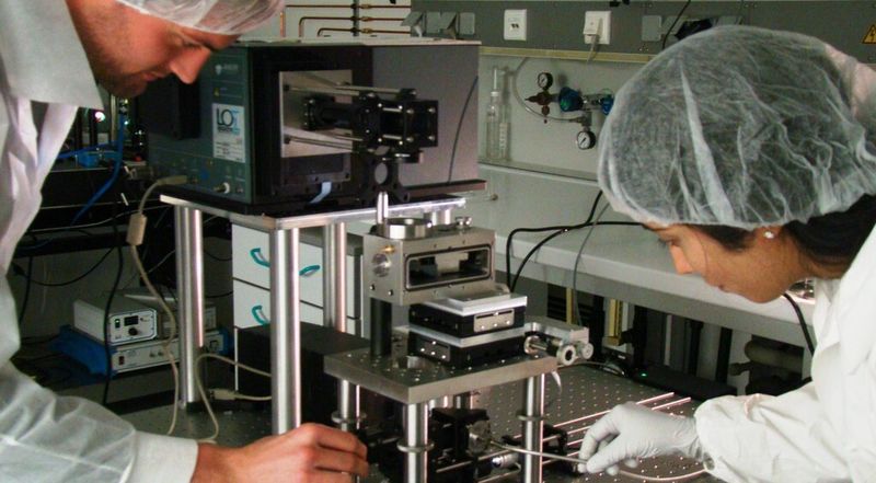 Thomas Utzig und Dr. Sangeetha Raman bei ihrem Versuchsaufbau zur Messung von Enthaftungsprozessen. Das Bild zeigt ein sogenanntes Rasterkraftmikroskop.