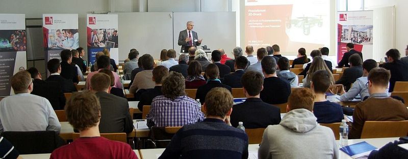 Prof. Dr. Karl Stoffel, Präsident der Hochschule Landshut, bei seiner Begrüßung mit einem an der Hochschule erstellten 3D-Duck-Modell der Martinskirche.