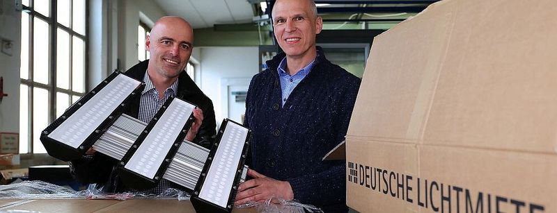 Die neuen dreiflammigen LED-Hallendeckenstrahler werden ausgepackt: Roman Teufl, Geschäftsführer Vertriebsgesellschaft Deutsche-Lichtmiete-Unternehmensgruppe, und Peter Andrä, Geschäftsführender Gesellschafter Riedl Aufzugbau GmbH & Co. KG.