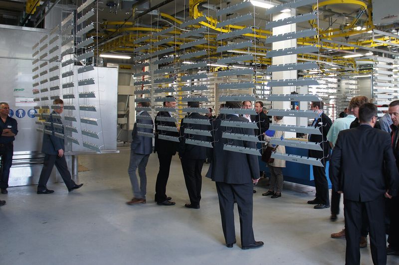 Zahlreiche Besucher fanden sich ein für die Einweihung der neuen Oberflächenbeschichtungsanlage (im Hintergrund) mit Handlingsystem (oben).