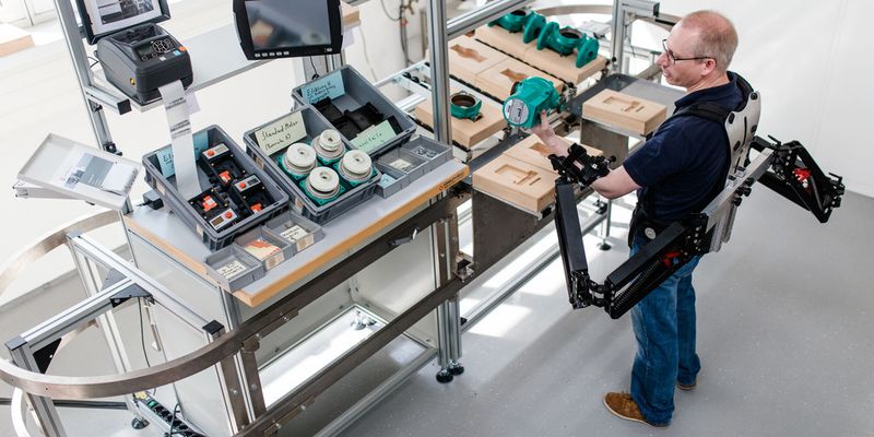 Dr. Konrad Stadler, Dozent für Regelungstechnik, Zürcher Hochschule für Angewandte Wissenschaften, demonstriert die Funktionsweise des Exoskeletts. Zu sehen ist die passive Unterstützung zum Heben schwerer Lasten.