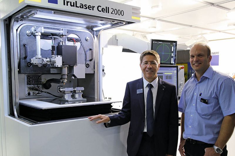 Hans Marfurt, Geschäftsführer der Trumpf Maschinen AG, und Pascal Perrin, Technischer Kundendienst, vor der neuen «TruLaser Cell 2000» am Messestand auf der EPHJ.