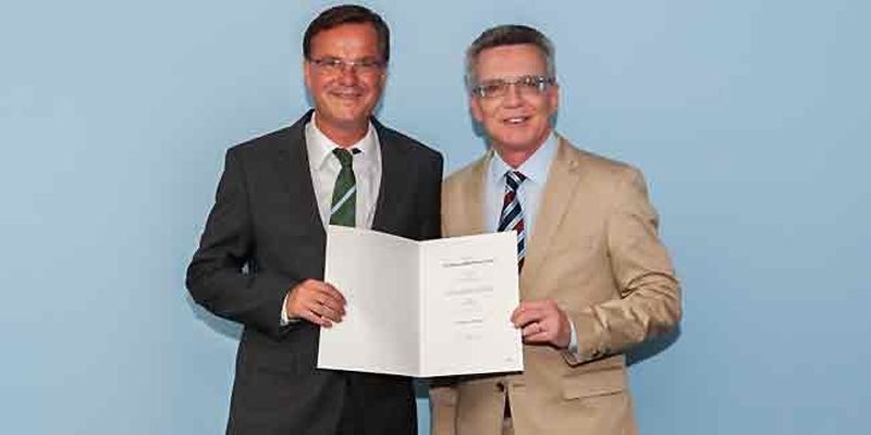 Bundesinnenminister de Maizière überreicht Engelke die Ernennungsurkunde
