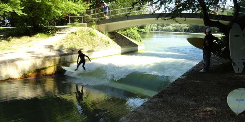 Surfer an der Floßlände in München bei traumhaften Bedingungen.