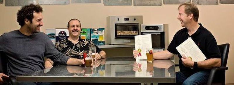 Die Unternehmensgründer von PicoBrew: Avi Geiger, Jim Mitchell und CEO Bill Mitchell. Im Hintergrund der Bierbrau-Automat Zymatic.