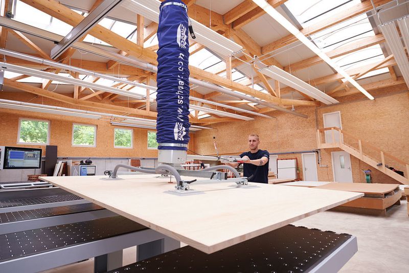 Der Vakuum-Schlauchheber JumboErgo 300 von Schmalz nimmt schwere Holzplatten mühelos auf und beschickt die Zuschnittmaschine bei Ziehli schnell und ergonomisch.