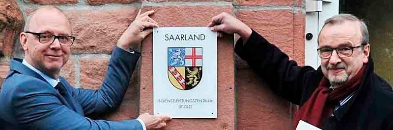 Auch im digitalen Zeitalter braucht man noch ein Türschild. Finanzstaatssekretär Dr. Axel Spies (r.) überreichte es Direktor Dr. Hanno Thewes zum offiziellen Start des IT-DLZ