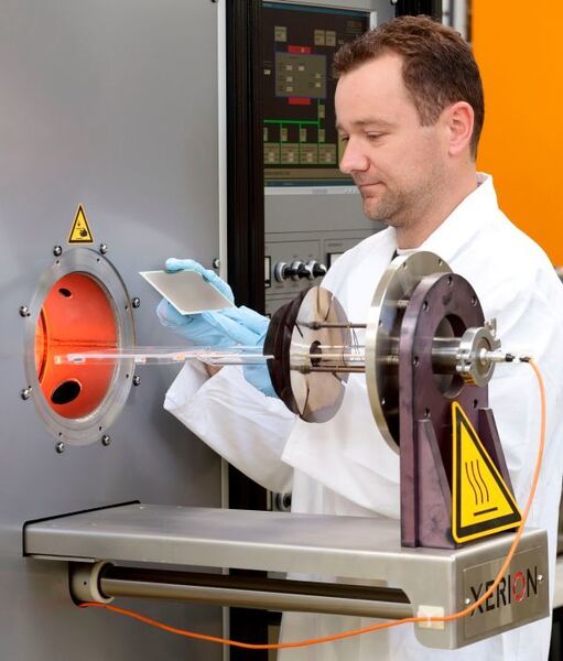 Sinter-Ofen: Frank Vondahlen hält eine Festoxid-Brennstoffzelle, die im Ofen bei Temperaturen von 1000 bis 1400 Grad gesintert wird.  (Forschungszentrum Jülich)