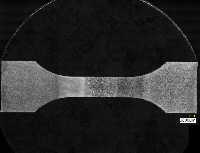 Eine Probe unterm Digitalmikroskop. Rechts ist der gegossene Stahl zu sehen, links der gedruckte, in der Mitte die Schweißnaht. Es ist deutlich zu erkennen, dass die Wärmeeinfluss des Schweißens unterschiedliche Auswirkungen auf die verschiedenen Materialien hat. (Bild: Hochschule Osnabrück)