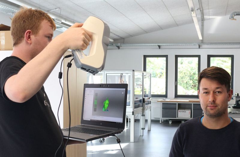 Herr Mauersberger (links, Konstruktionsstudent Hochschule Mittweida) und Herr Petzold (rechts, Projektverantwortlicher an der Hochschule Mittweida) beim 3D Scannen. Dank der neuartigen Technik können Prothesen in weniger als einer Stunde gedruckt werden. (JAT)