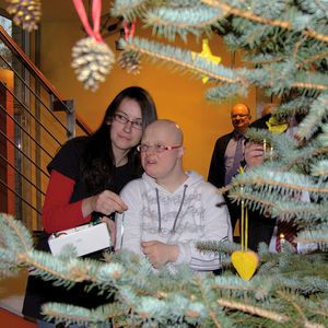 Eine Heimbewohnerin schmückt mit ihrer Helferin den Weihnachtsbaum bei SPS.