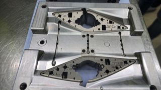 The back of the speaker grill — the sprue system of the four-cavity mould for left and right parts is clearly visible. The ejector set is mounted directly in the center.  (Source: Pergler Media)