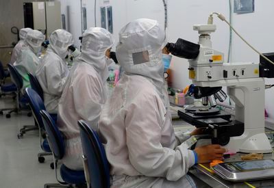 Präzisionsarbeit an optoelektronische Komponenten unter dem Mikroskop  (Focuz Manufacturing)