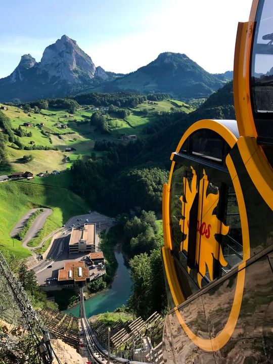 Die Standseilbahn Schwyz-Stoos auf der Bahnstrecke. Die fassförmigen Kabinen mit automatischen Niveauregulierung ermöglichen, dass die Fahrgäste stets auf einer waagrechten Fläche stehen, während sich die Bahn fast senkrecht die Wand hochschiebt.(Bild:  Stoosbahnen AG, Luca Küng)