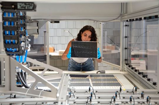 Die Projektleiterin am Fraunhofer ISE, Najwa Abdel Latif kontrolliert die verschalteten Solarzellen am Schindel-Matrix-Stringer des Fraunhofer ISE. (Bild:  Fraunhofer ISE / Sophia Bächle)